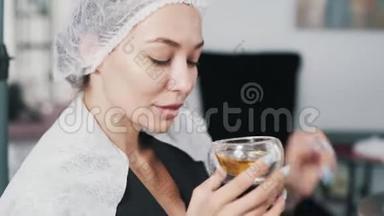 美容帽上的美女在美容院喝茶，做头发护理